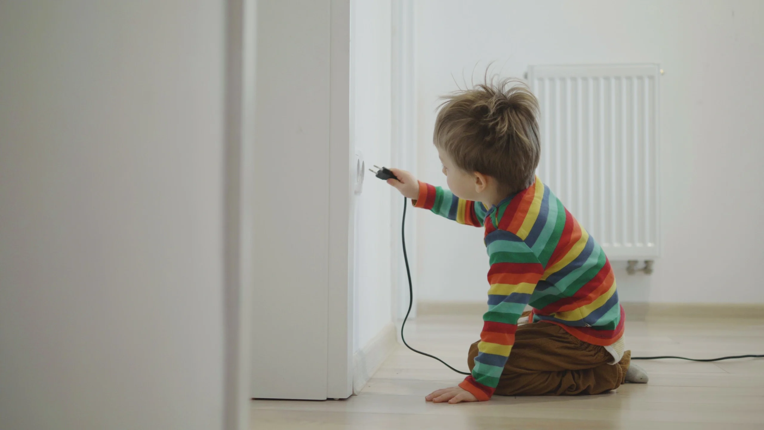 Child sitting on the floor and plugin a cable